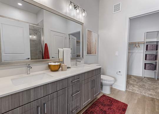 A bathroom with a red rug in front of a sink.