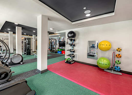 A gym with a red mat in the middle of the room.