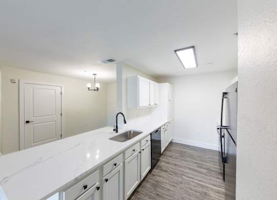 A kitchen with white countertops and a sink.