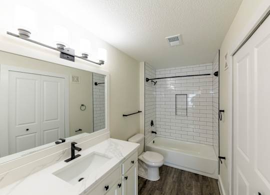 A white bathroom with a sink, toilet, and bathtub.