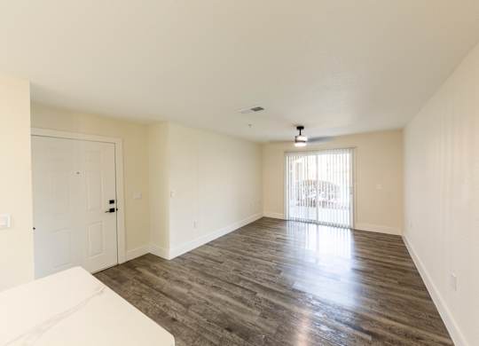 A spacious room with wooden flooring and a white sofa.