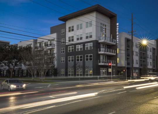 A long exposure shot of a street with cars and buildings at dusk.