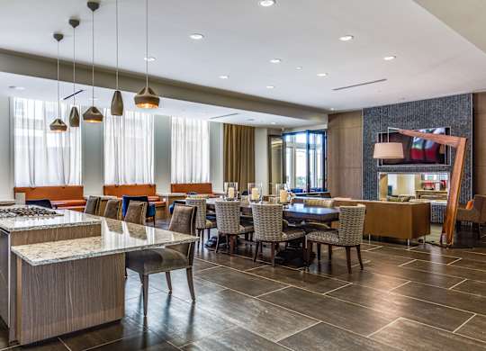 A modern dining room with a long table and chairs.