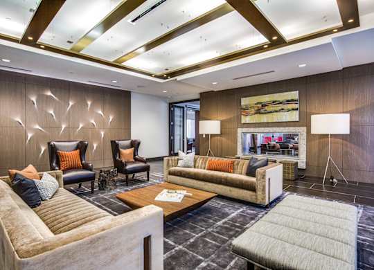 A modern living room with a large couch, two chairs, and a coffee table.