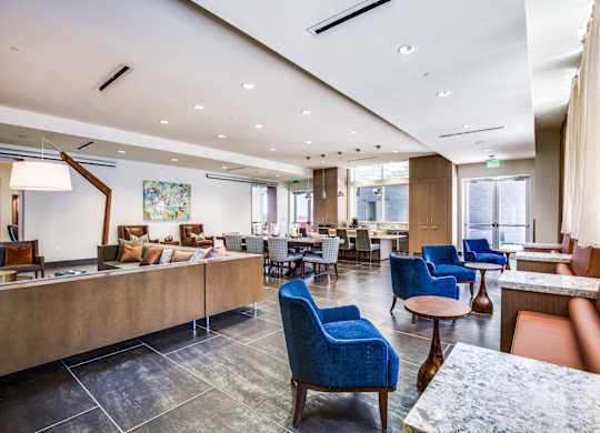 A modern living room with blue chairs and a wooden table.