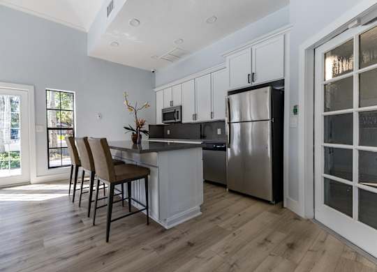 A kitchen with a refrigerator, microwave, and oven.