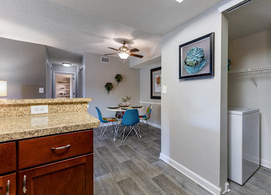 A kitchen with a counter and a dining table with chairs.
