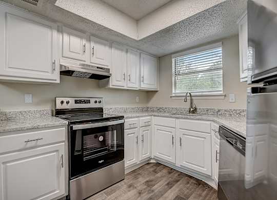 a kitchen with white cabinets and stainless steel appliances