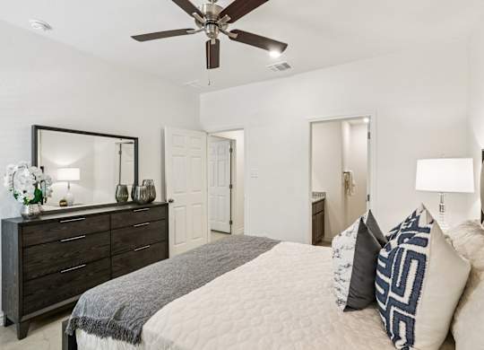 A bedroom with a bed, dresser, and mirror.