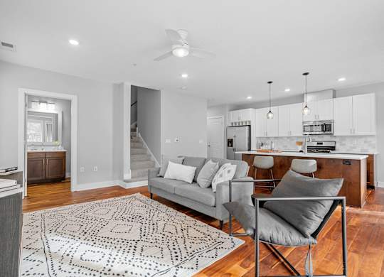 a living room with a couch and a chair and a kitchen