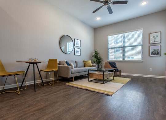 A living room with a yellow chair and a beige couch.