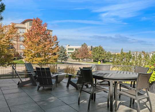 A patio with a table and chairs overlooking a city.