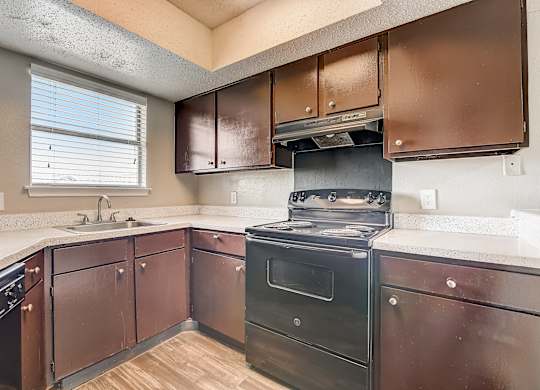 a kitchen with dark cabinets and white countertops