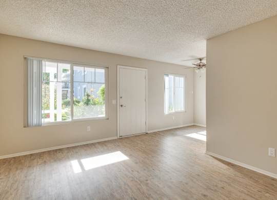 A room with a ceiling fan and a door leading to a balcony.