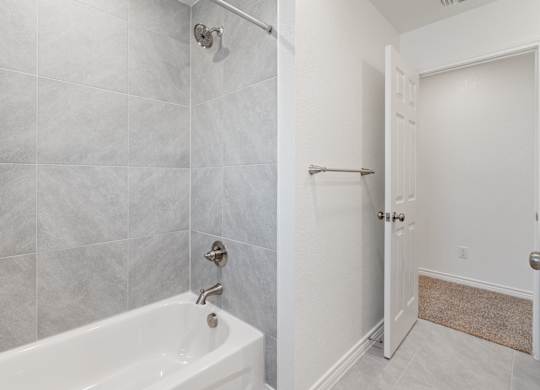 a bathroom with a tub and a shower and a door
