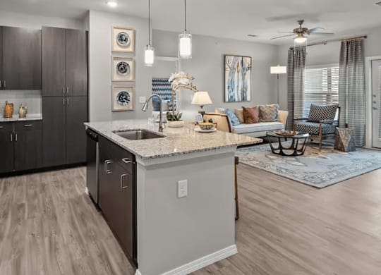 A modern kitchen with a large island and a dining area with a couch and chairs.