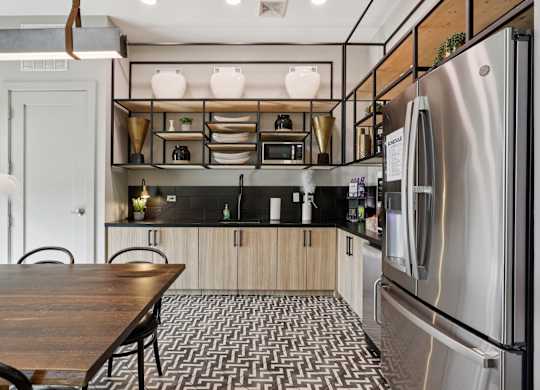A modern kitchen with a wooden table and stainless steel appliances.