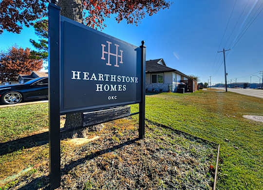 A sign for Hearthstone Homes in Oklahoma City stands in front of a house.