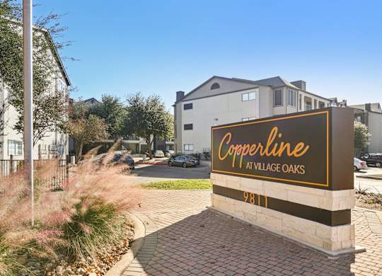 A sign for Copperline at Village Oaks stands in front of a building.