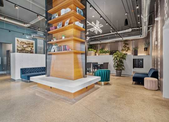 A modern office space with a tall bookshelf filled with books and a white platform at the base.