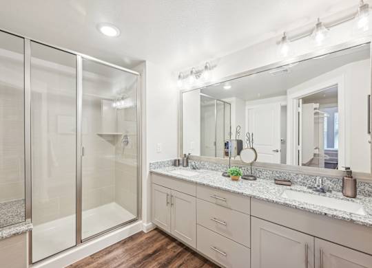 A bathroom with a large mirror and a walk-in shower.