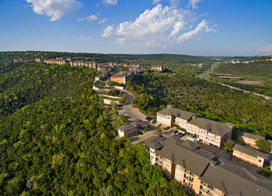 A bird's eye view of a residential area surrounded by a dense forest.