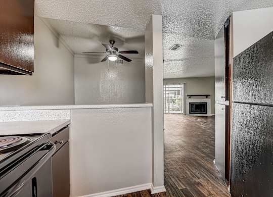 a kitchen and living room with a ceiling fan