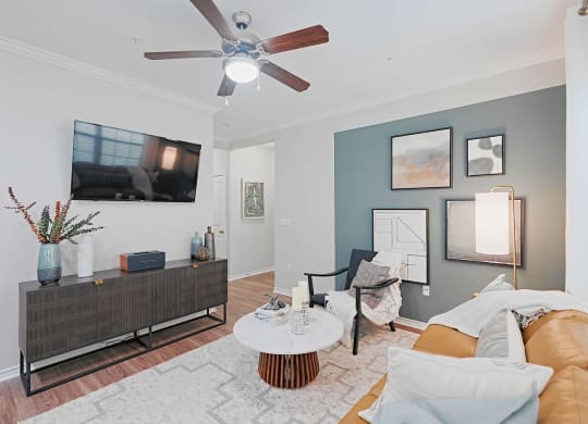 a living room with a couch and a ceiling fan