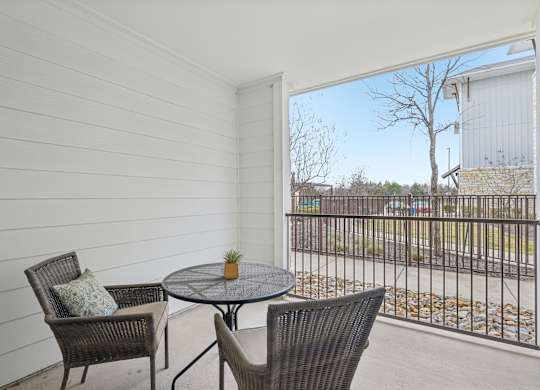A balcony with a table and two chairs.