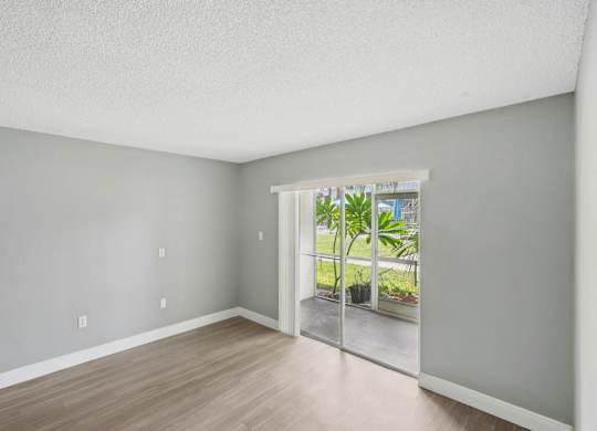 A room with a sliding glass door leading to a balcony.