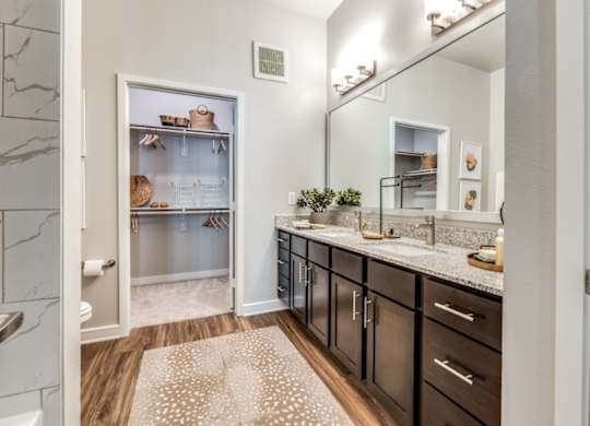 A kitchen with a refrigerator, countertops, and a rug on the floor.