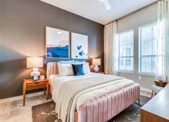 A bedroom with a large bed and a painting on the wall.