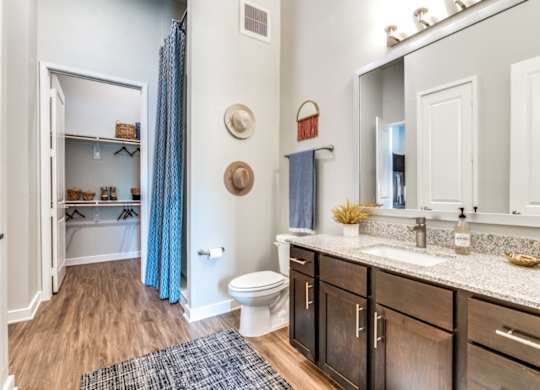 A bathroom with a toilet, sink, and a mirror.