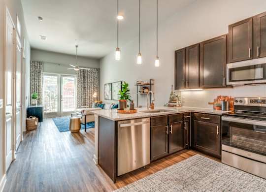 A modern kitchen with dark wood cabinets and stainless steel appliances.