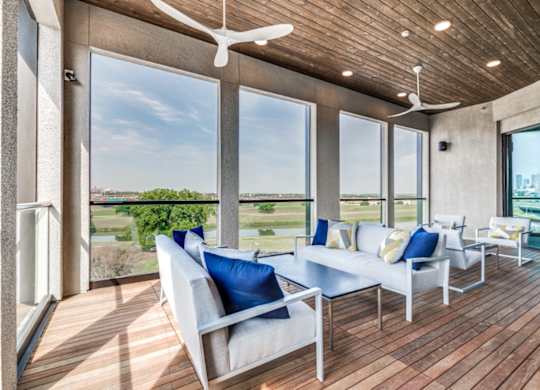 A modern living room with a wooden floor and a ceiling fan.