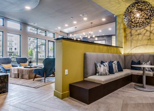 A modern living room with a yellow accent wall and a large window.