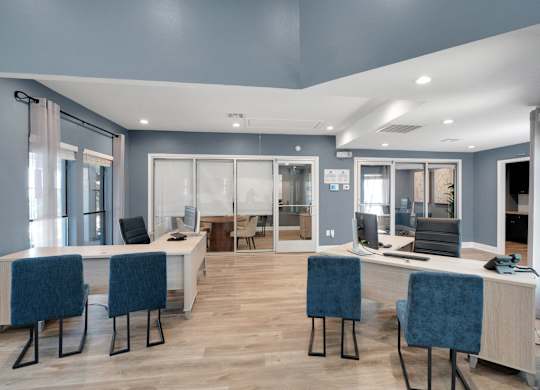 A modern office with blue chairs and white desks.