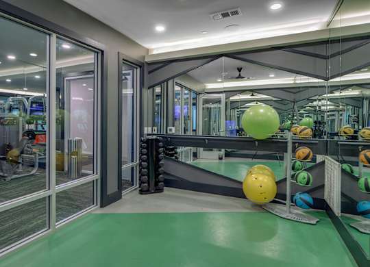 A gym with a green floor and a variety of exercise equipment.