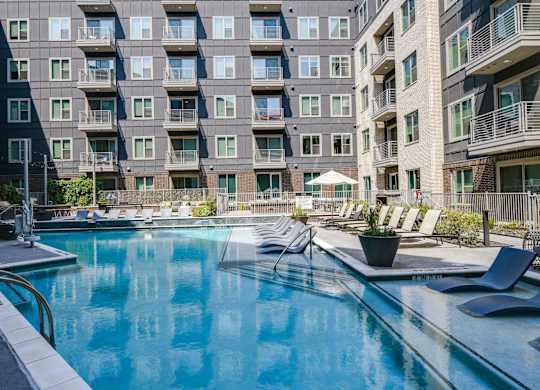 A large swimming pool in front of apartment buildings.