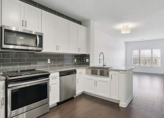 A kitchen with white cabinets and stainless steel appliances.