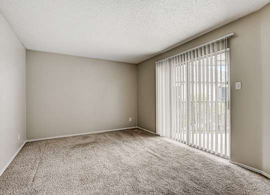 a bedroom with a large window and a carpeted floor