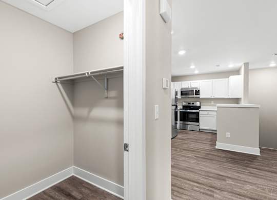 a renovated living room with a closet and a kitchen