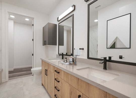 a bathroom with two sinks and two mirrors