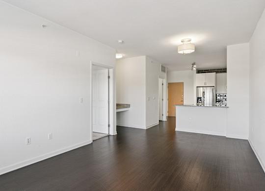 A large empty room with wooden floors and white walls.