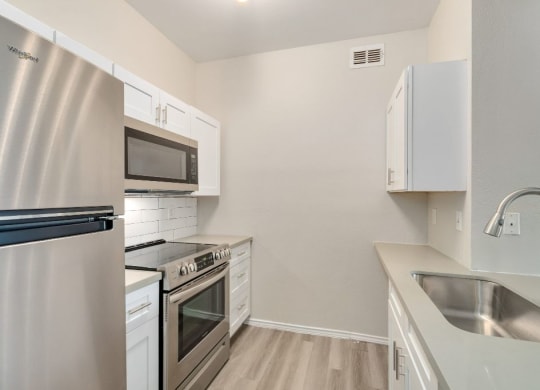 a kitchen with stainless steel appliances and white cabinets