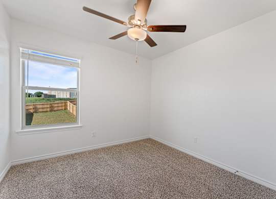 an empty room with a ceiling fan and a window