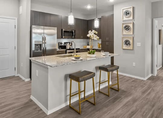 A modern kitchen with a marble countertop and stainless steel appliances.