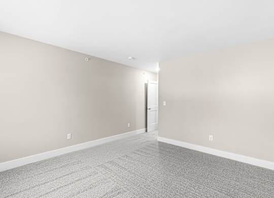 a living room with a carpeted floor and white walls