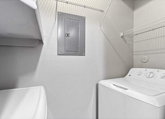 a white laundry room with a white washer and dryer and a white sink