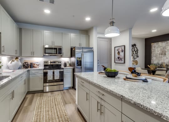 an open kitchen with white cabinets and granite counter tops